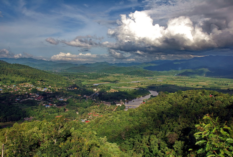 Chiang Rai-Chaing Mai border during the rainy season. Some clouds but green and the river's full.